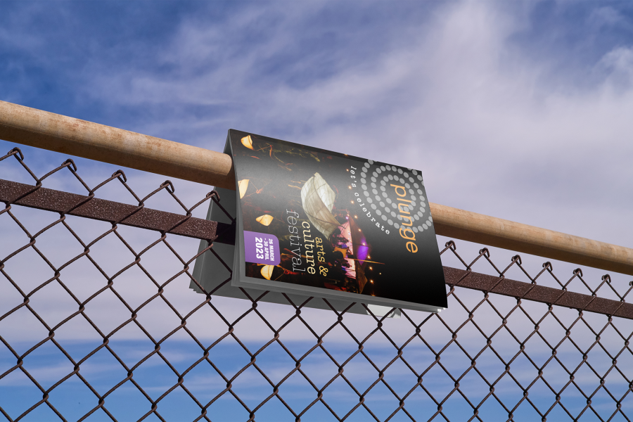 Image of Plunge magazine, hanging over a handrail with ocean in the background